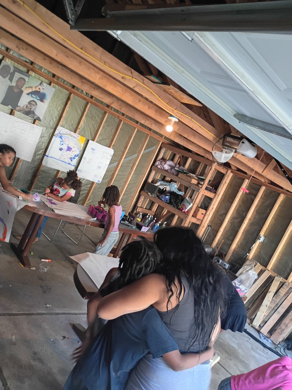 Children gathered around art tables in the garage