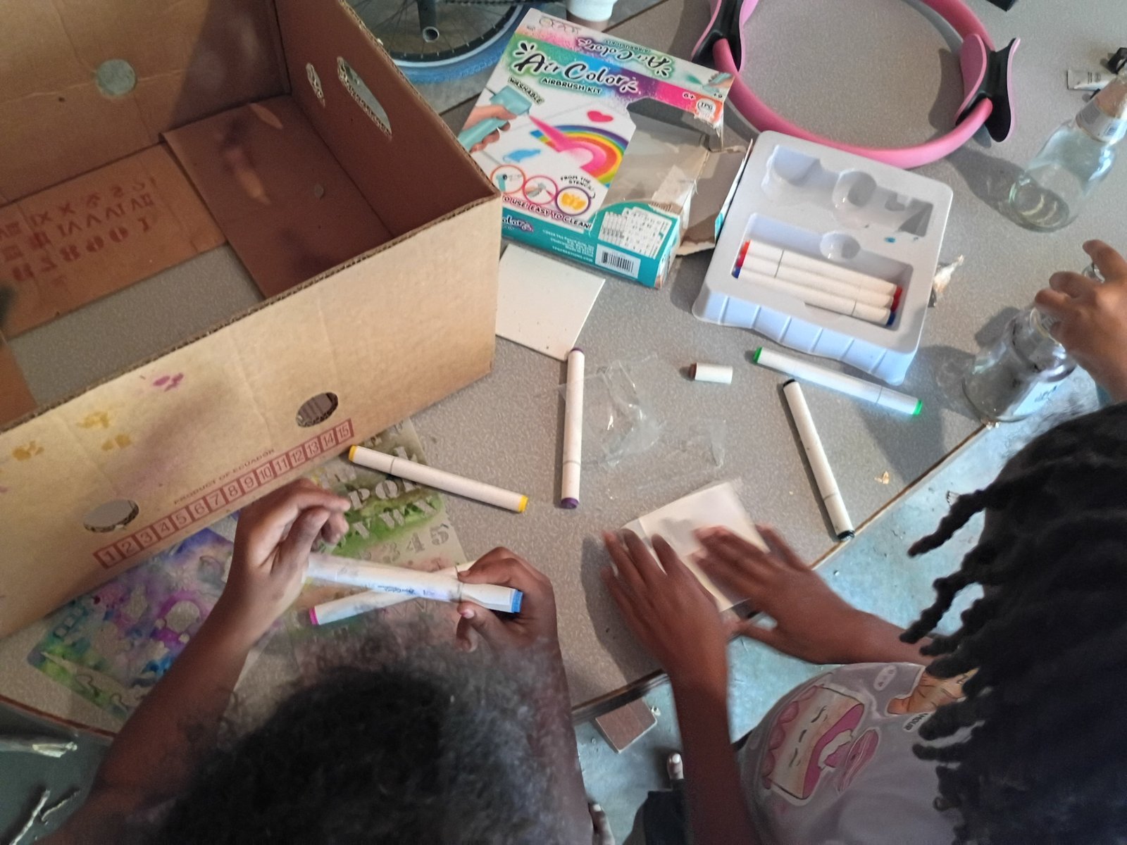 Children painting together at a table filled with supplies